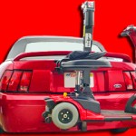 Burbank Electropedic TRILIFT Ultra Lite Lift carrying a Pride GoGo Ultra on A Ford Mustang Convertible.