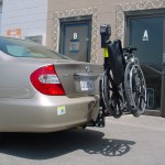Burbank Electropedic TRILIFT Ultra Lite carrying a manual wheelchair on a Toyota Camry.
